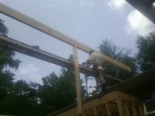 Carpenter setting a ridge beam over a new addition frame — Ice Dam Removal by Roofing Brothers in Lostine