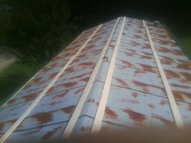 Rusted metal roof panels with new wood purlins before replacement — Storm Damage Roof Repair in Lostine by Roofing Brothers